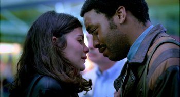 Movie still from “Dirty Pretty Things” (2002), directed by Stephen Frears – A man and a woman face to face in front of a crowd; Close Up shot, Low angle