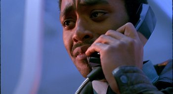 Movie still from “Dirty Pretty Things” (2002), directed by Stephen Frears – A person talking on a cell phone; Close Up shot, Low angle