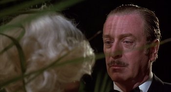 Movie still from “Dirty Rotten Scoundrels” (1988), directed by Frank Oz – A person looking at a flower; Close Up shot, Low angle