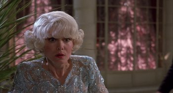 Movie still from “Dirty Rotten Scoundrels” (1988), directed by Frank Oz – An older woman with white hair and wearing a blue dress; Close Up shot, Low angle