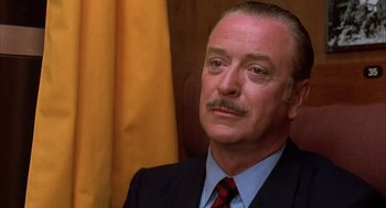 Movie still from “Dirty Rotten Scoundrels” (1988), directed by Frank Oz – A person wearing a suit and tie; Close Up shot, Low angle