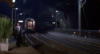Movie still from “Dirty Rotten Scoundrels” (1988), directed by Frank Oz – A train on a track at night with lights on; Extreme Wide shot, High angle