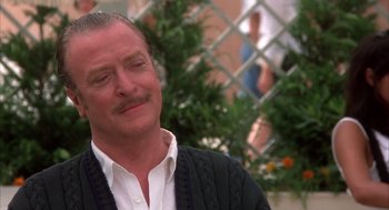 Movie still from “Dirty Rotten Scoundrels” (1988), directed by Frank Oz – A person wearing a sweater and a white shirt; Close Up shot, Low angle