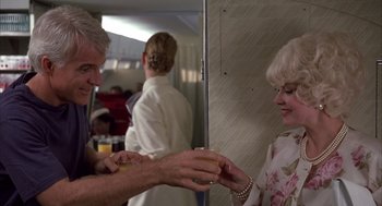 Movie still from “Dirty Rotten Scoundrels” (1988), directed by Frank Oz – A man and a woman holding a glass of beer; Medium shot, Low angle