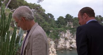 Two men standing next to each other near a body of water