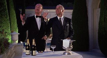 Movie still from “Dirty Rotten Scoundrels” (1988), directed by Frank Oz – Two men in tuxedos are holding wine glasses; Medium shot, Low angle
