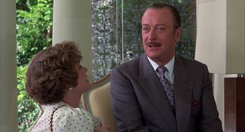 Movie still from “Dirty Rotten Scoundrels” (1988), directed by Frank Oz – An older man in a suit and tie talking to an older woman in a polka dot dress; Close Up shot, Over the shoulder angle