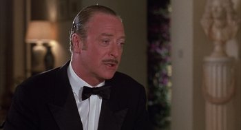 An older man in a black suit and a black bow tie