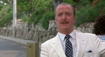 Movie still from “Dirty Rotten Scoundrels” (1988), directed by Frank Oz – A person wearing a suit and tie; Close Up shot, Low angle
