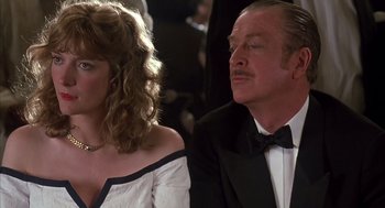 Movie still from “Dirty Rotten Scoundrels” (1988), directed by Frank Oz – A man and a woman sitting next to each other in formal wear; Close Up shot, Over the shoulder angle