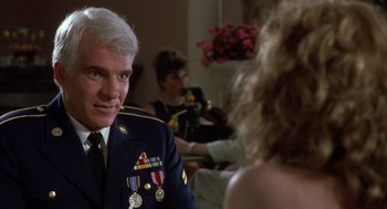 Movie still from “Dirty Rotten Scoundrels” (1988), directed by Frank Oz – A man in a military uniform sitting in front of a woman; Close Up shot, Over the shoulder angle