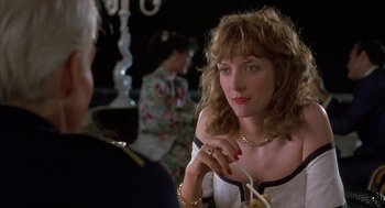 Movie still from “Dirty Rotten Scoundrels” (1988), directed by Frank Oz – A woman sitting in front of a mirror holding a cigarette; Close Up shot, Over the shoulder angle
