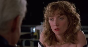 Movie still from “Dirty Rotten Scoundrels” (1988), directed by Frank Oz – A person wearing a necklace; Close Up shot, Over the shoulder angle