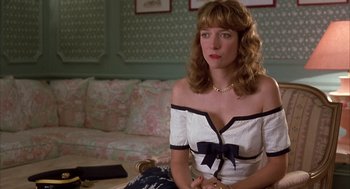 Movie still from “Dirty Rotten Scoundrels” (1988), directed by Frank Oz – A woman sitting on the floor in a living room; Medium shot, Over the shoulder angle