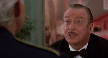 Movie still from “Dirty Rotten Scoundrels” (1988), directed by Frank Oz – An older man wearing a tuxedo and a bow tie; Close Up shot, Over the shoulder angle
