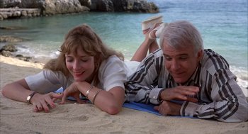 Movie still from “Dirty Rotten Scoundrels” (1988), directed by Frank Oz – A man and a woman laying on the beach; Medium shot, High angle