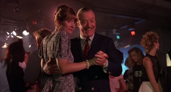 Movie still from “Dirty Rotten Scoundrels” (1988), directed by Frank Oz – A man and a woman are dancing in a room; Medium shot, Low angle