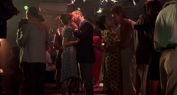 Movie still from “Dirty Rotten Scoundrels” (1988), directed by Frank Oz – A man and a woman are dancing in a crowd; Wide shot, High angle