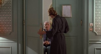 Movie still from “Dirty Rotten Scoundrels” (1988), directed by Frank Oz – An older man and a young woman are talking; Medium shot, Over the shoulder angle