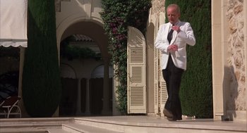 Movie still from “Dirty Rotten Scoundrels” (1988), directed by Frank Oz – A man in a white suit walking down a set of steps; Wide shot, Low angle
