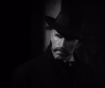 Movie still from “Dishonored” (1931), directed by Josef von Sternberg – A man with a mustache wearing a hat and a coat; Close Up shot, Low angle