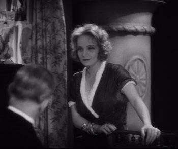 Movie still from “Dishonored” (1931), directed by Josef von Sternberg – An old photo of a woman standing in front of a man; Medium shot, Over the shoulder angle