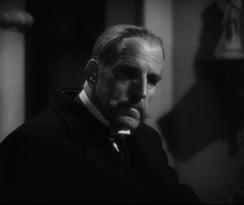 Movie still from “Dishonored” (1931), directed by Josef von Sternberg – An older man in a suit with a mustache; Close Up shot, Low angle