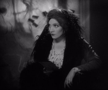Movie still from “Dishonored” (1931), directed by Josef von Sternberg – An old photo of a woman sitting in a chair; Medium shot, Low angle