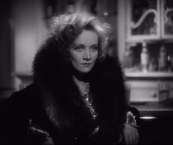 Movie still from “Dishonored” (1931), directed by Josef von Sternberg – An old photo of a woman in a black dress and a fur coat; Close Up shot, Low angle
