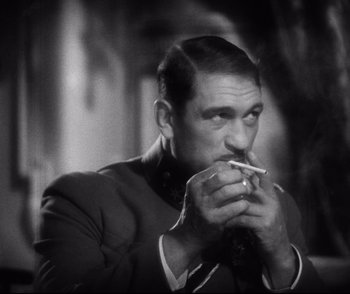 Movie still from “Dishonored” (1931), directed by Josef von Sternberg – A black and white photo of a man smoking a cigarette; Close Up shot, Low angle