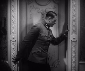 Movie still from “Dishonored” (1931), directed by Josef von Sternberg – A black and white photo of a man in a suit; Medium shot, Low angle