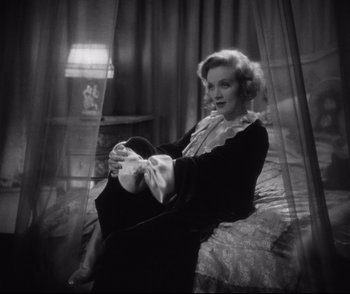 Movie still from “Dishonored” (1931), directed by Josef von Sternberg – A woman sitting on a bed in a room; Medium shot, High angle
