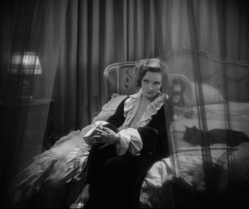 Movie still from “Dishonored” (1931), directed by Josef von Sternberg – A woman sitting on a chair in a room; Medium shot, High angle