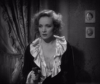 Movie still from “Dishonored” (1931), directed by Josef von Sternberg – A black and white photo of a woman holding a camera; Medium shot, High angle