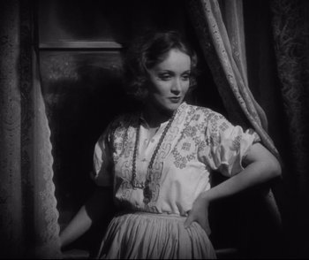 Movie still from “Dishonored” (1931), directed by Josef von Sternberg – A black and white photo of a woman standing in front of a window; Medium shot, Low angle