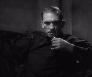 Movie still from “Dishonored” (1931), directed by Josef von Sternberg – A black and white photo of a man holding a knife; Medium shot, Low angle