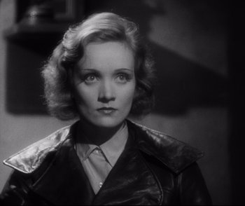 Movie still from “Dishonored” (1931), directed by Josef von Sternberg – A black and white photo of a woman in a leather jacket; Close Up shot, High angle