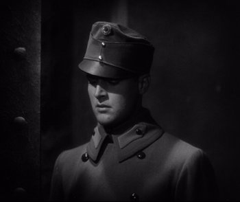 Movie still from “Dishonored” (1931), directed by Josef von Sternberg – A man in a military uniform stands in front of a wall; Close Up shot, Low angle