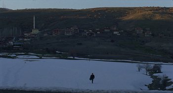 Movie still from “Distant” (2002), directed by Nuri Bilge Ceylan – A man walking across a snow covered field; Extreme Wide shot, High angle