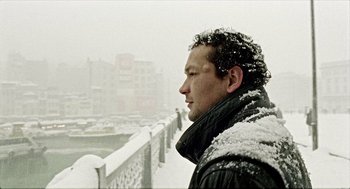Movie still from “Distant” (2002), directed by Nuri Bilge Ceylan – A man standing on a bridge in the snow; Close Up shot, Low angle
