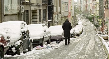 Movie still from “Distant” (2002), directed by Nuri Bilge Ceylan – A man walking down a street in the snow; Wide shot, High angle