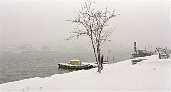 Movie still from “Distant” (2002), directed by Nuri Bilge Ceylan – A person standing on a dock in the snow; Extreme Wide shot, Low angle