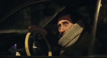Movie still from “Distant” (2002), directed by Nuri Bilge Ceylan – A man sitting in the drivers seat of a car; Close Up shot, Low angle