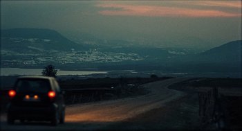 Movie still from “Distant” (2002), directed by Nuri Bilge Ceylan – Two people are standing on the side of a road; Extreme Wide shot, Low angle