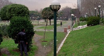 Movie still from “Distant” (2002), directed by Nuri Bilge Ceylan – Two people are walking on a path in a park; Extreme Wide shot, High angle