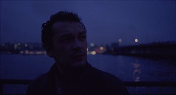 Movie still from “Distant” (2002), directed by Nuri Bilge Ceylan – A person in a boat on a body of water; Close Up shot, Low angle
