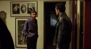 Movie still from “Distant” (2002), directed by Nuri Bilge Ceylan – Two men standing in front of each other in front of a door; Medium shot, Over the shoulder angle