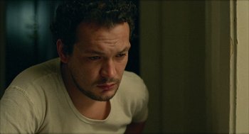 Movie still from “Distant” (2002), directed by Nuri Bilge Ceylan – A person sitting down with his eyes closed; Close Up shot, High angle