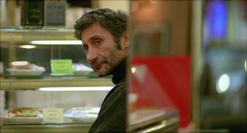 Movie still from “Distant” (2002), directed by Nuri Bilge Ceylan – A person sitting at a table; Close Up shot, Over the shoulder angle