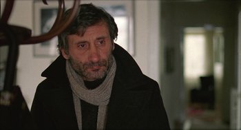 Movie still from “Distant” (2002), directed by Nuri Bilge Ceylan – A person wearing a coat and a scarf; Close Up shot, Over the shoulder angle
